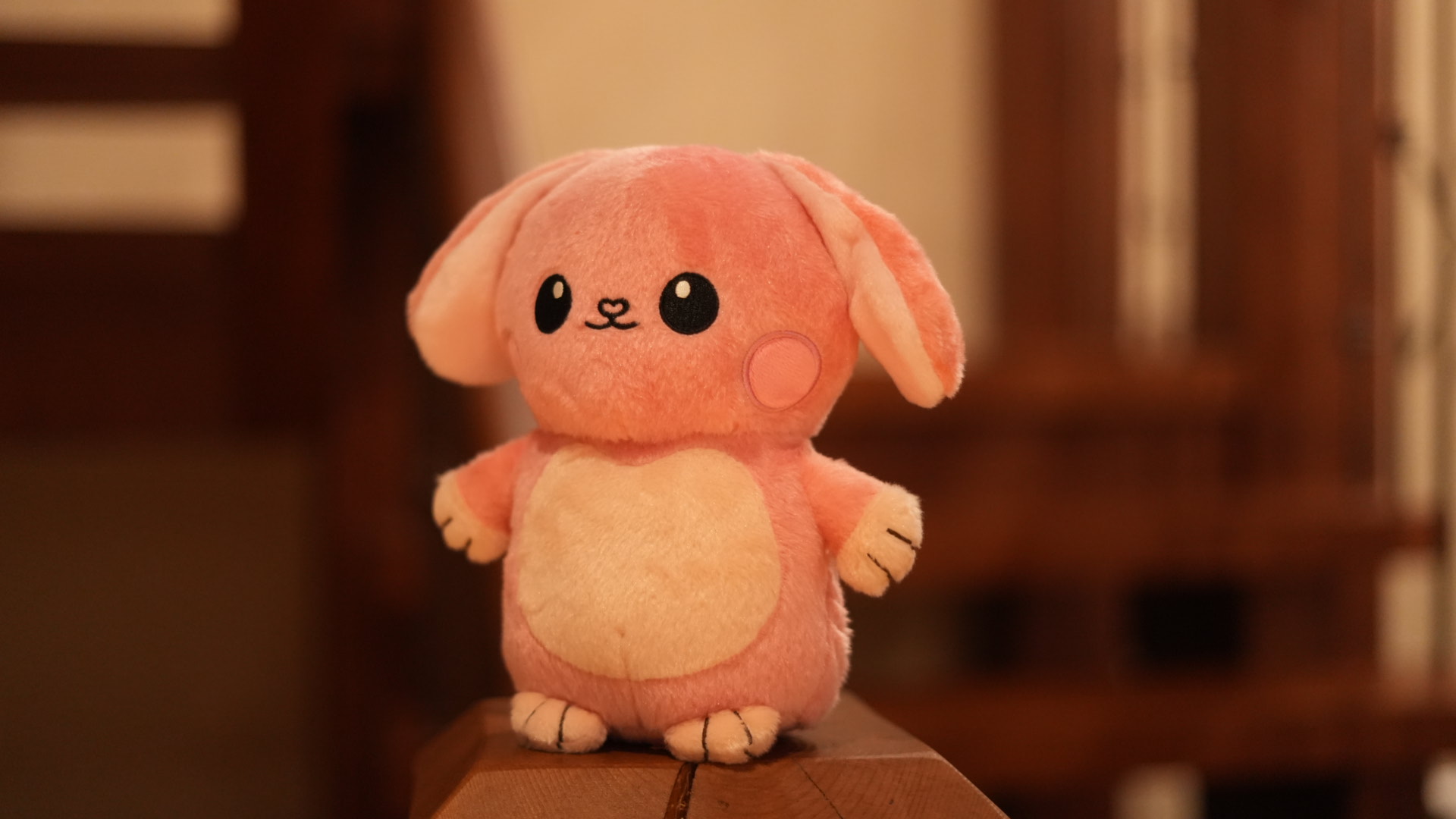Glow Buddy standing on a stack of wooden blocks in warm daylight.
